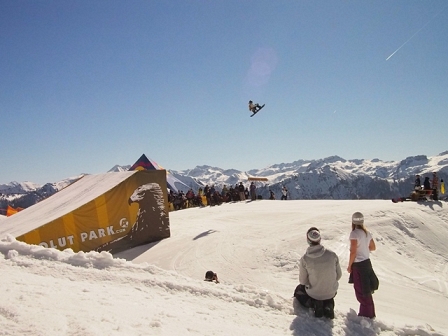 Snowboarder springt über Schanze